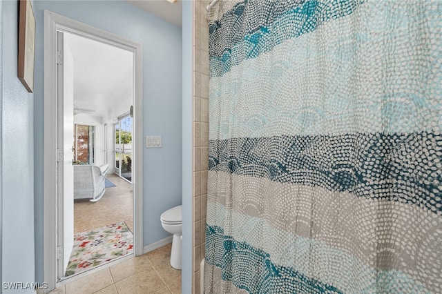 bathroom featuring tile patterned floors, a shower with shower curtain, and toilet