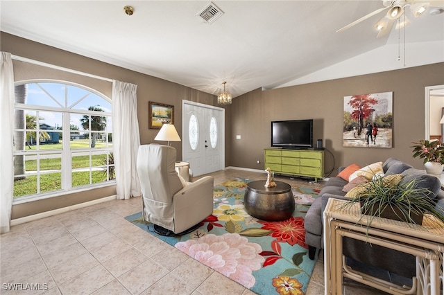 tiled living room featuring ceiling fan with notable chandelier and lofted ceiling