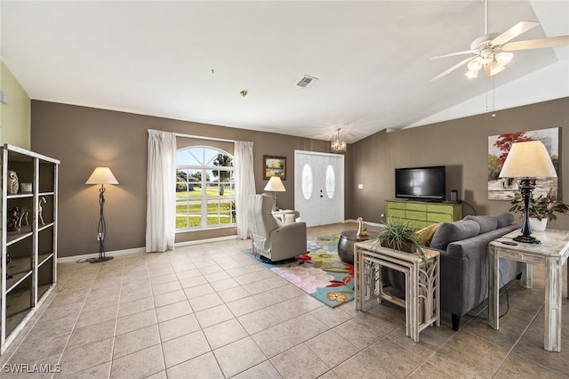 living room with light tile patterned floors, ceiling fan with notable chandelier, and lofted ceiling