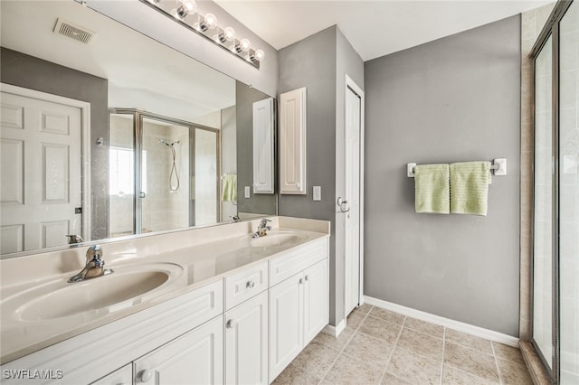 bathroom featuring tile patterned flooring, vanity, and walk in shower