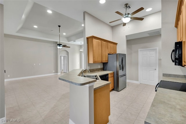 kitchen with kitchen peninsula, ceiling fan, sink, and black appliances