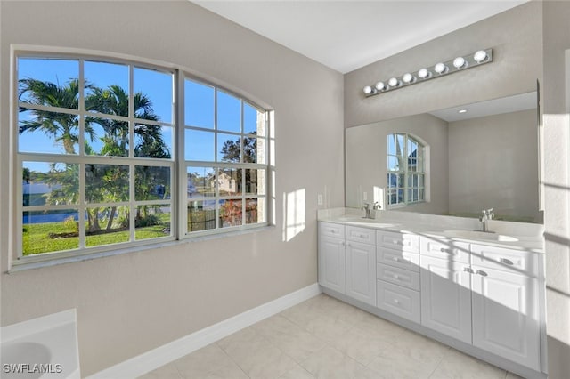 bathroom with tile patterned flooring, vanity, and a healthy amount of sunlight