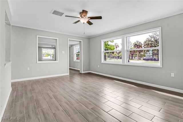 empty room with ceiling fan, light hardwood / wood-style flooring, and crown molding