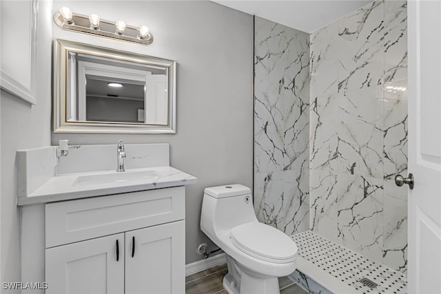 bathroom featuring tiled shower, vanity, and toilet