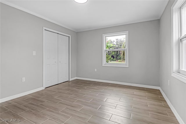 unfurnished bedroom featuring a closet, light hardwood / wood-style flooring, and crown molding