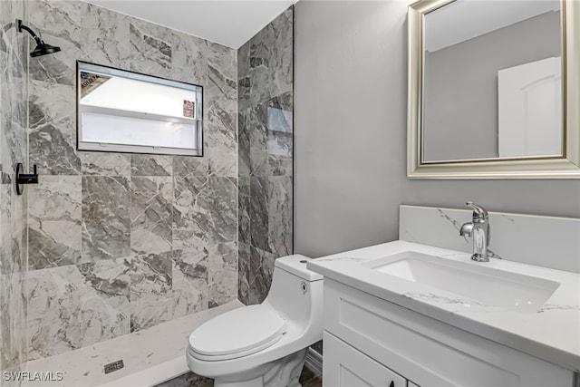 bathroom featuring tiled shower, vanity, and toilet