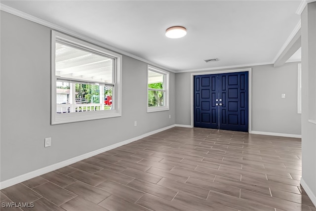 foyer with light hardwood / wood-style floors and crown molding