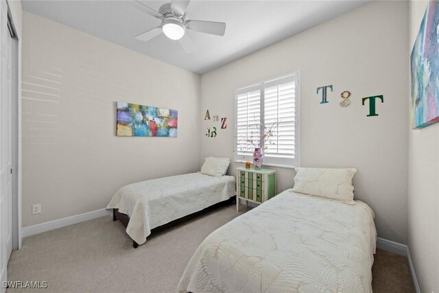 bedroom with ceiling fan, carpet floors, and a closet