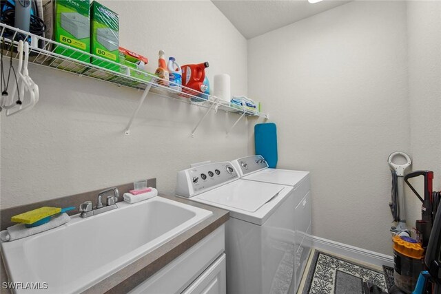 clothes washing area featuring independent washer and dryer and sink