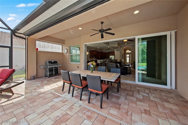 view of patio / terrace featuring a lanai, area for grilling, and ceiling fan