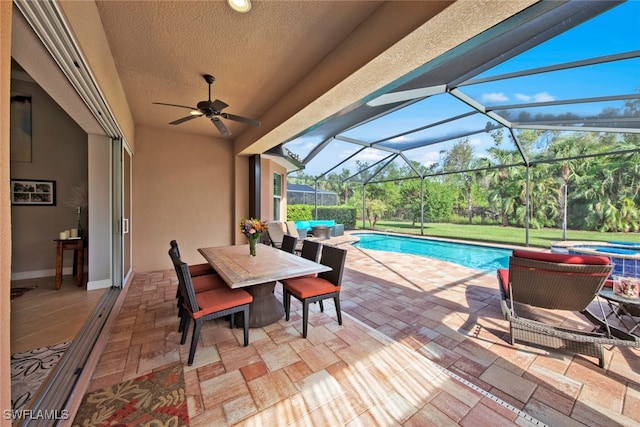 view of swimming pool featuring ceiling fan, a patio area, a lanai, and an outdoor living space