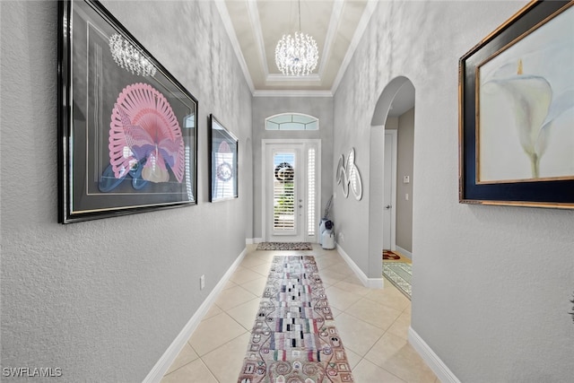 interior space with a notable chandelier, light tile patterned floors, and crown molding