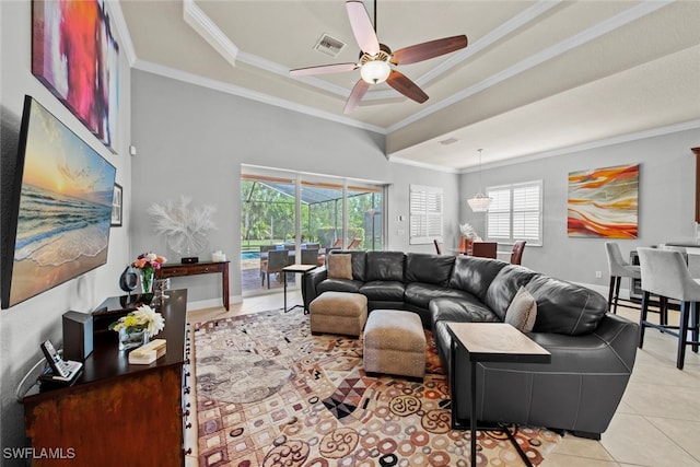 living room with ceiling fan, a raised ceiling, light tile patterned floors, and crown molding