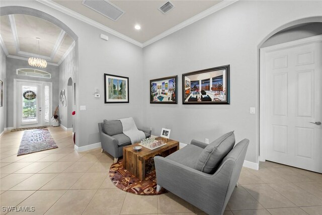 living room featuring light tile patterned flooring, crown molding, and an inviting chandelier