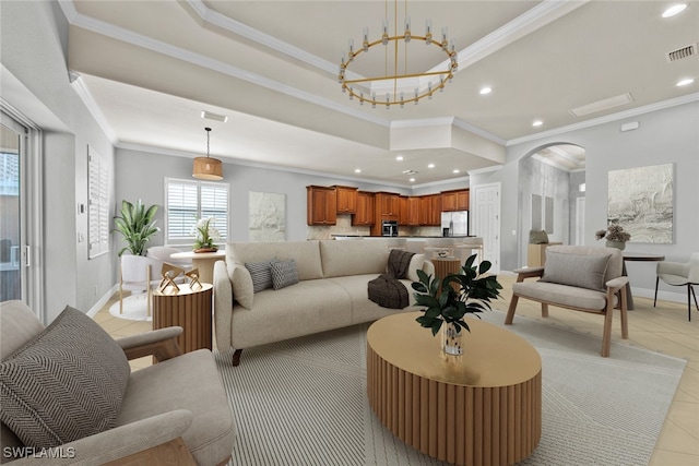 living room featuring ornamental molding, light tile patterned floors, and a tray ceiling