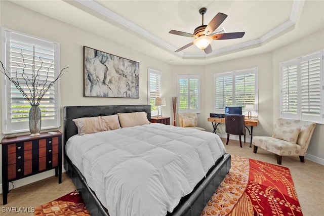 tiled bedroom with ornamental molding, ceiling fan, and a tray ceiling