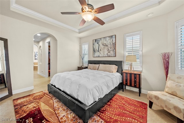 bedroom featuring a raised ceiling, ceiling fan, crown molding, and light tile patterned floors