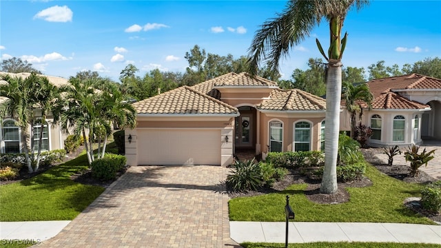 mediterranean / spanish-style home with a garage and a front lawn