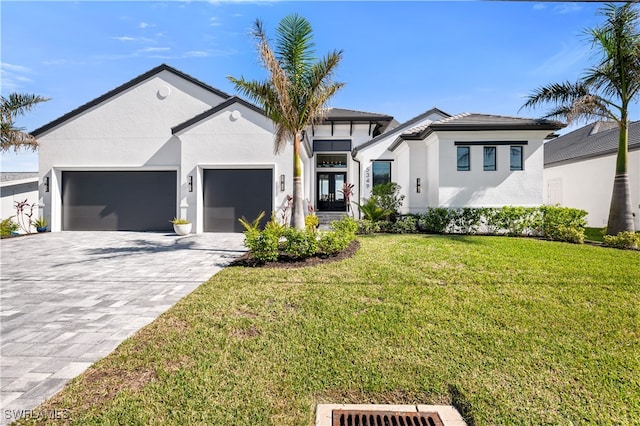 view of front of home with french doors, a front yard, and a garage