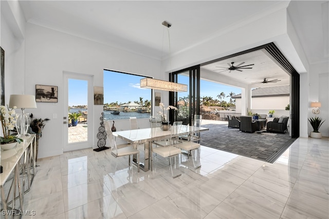 dining space featuring a water view, a wealth of natural light, ornamental molding, and ceiling fan