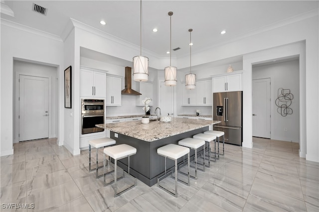 kitchen featuring a center island with sink, wall chimney exhaust hood, white cabinets, and stainless steel appliances