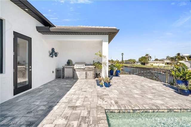 view of patio featuring a water view, area for grilling, and grilling area