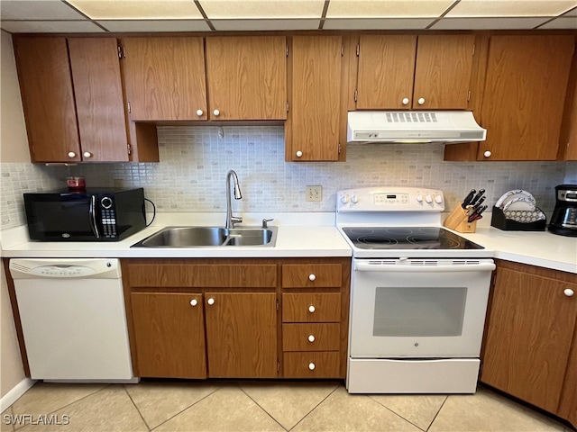 kitchen featuring sink, light tile patterned floors, a drop ceiling, and white appliances