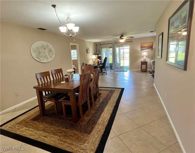 dining area with light tile patterned floors and ceiling fan with notable chandelier