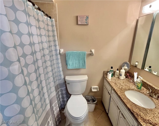 bathroom with toilet, vanity, and tile patterned floors