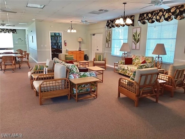 living room with carpet and ceiling fan with notable chandelier