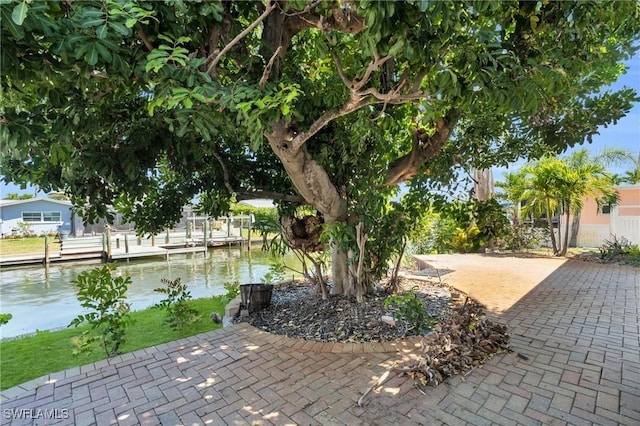 view of patio / terrace featuring a water view and a boat dock