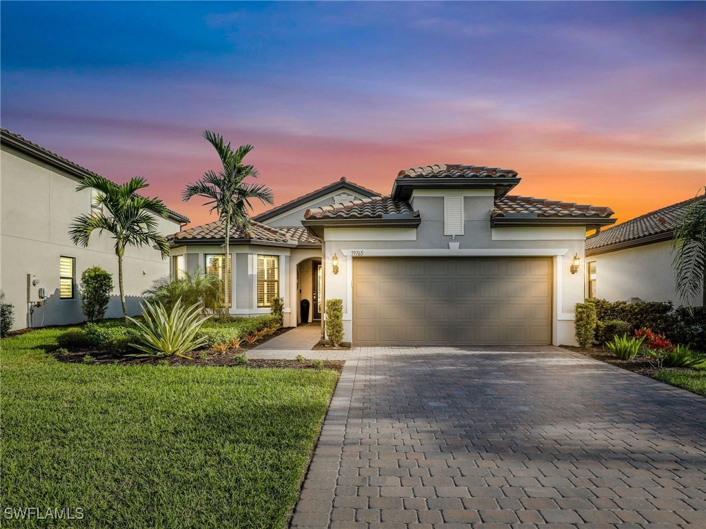 mediterranean / spanish-style house featuring a garage and a lawn