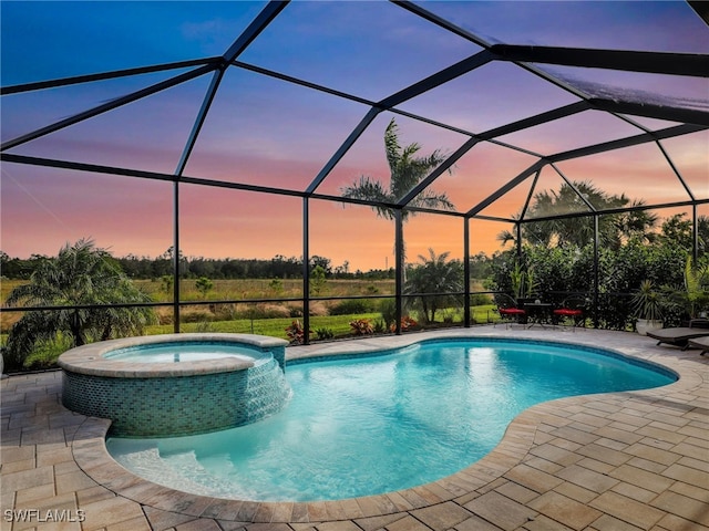 pool at dusk featuring a patio area and a lanai