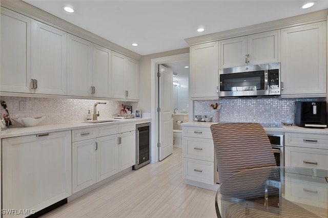 kitchen with sink, beverage cooler, and tasteful backsplash