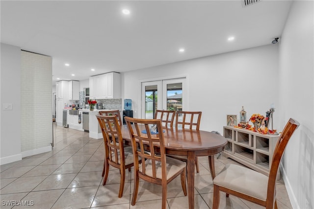 dining area featuring light tile patterned floors and french doors