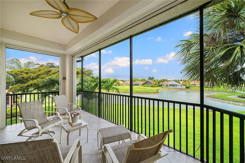 sunroom with a water view, a wealth of natural light, and ceiling fan