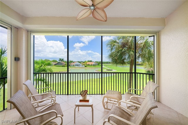 sunroom / solarium featuring a water view and ceiling fan