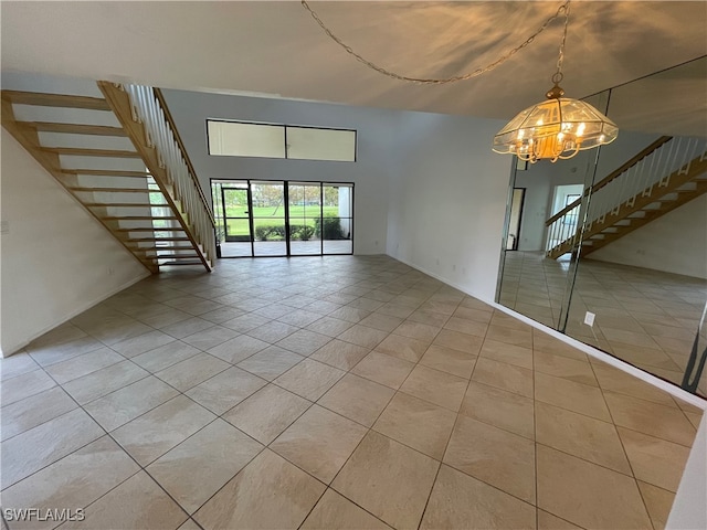 empty room with light tile patterned flooring and an inviting chandelier