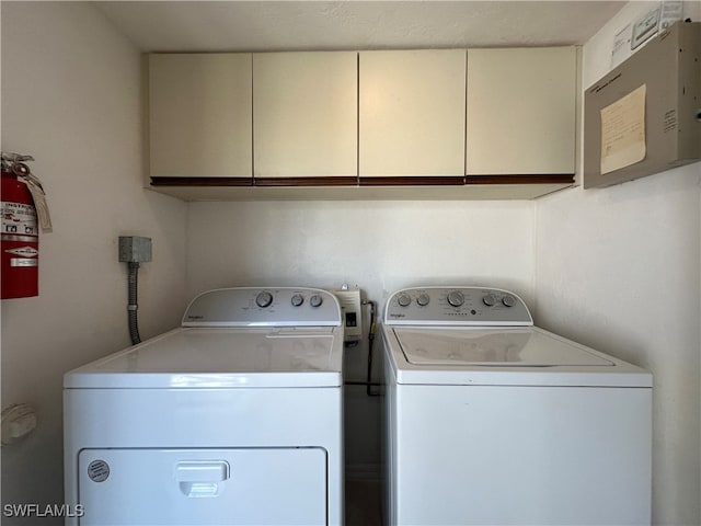 washroom with cabinets and washing machine and clothes dryer