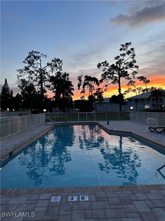 pool at dusk with a patio