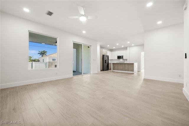 unfurnished living room with light wood-type flooring and ceiling fan