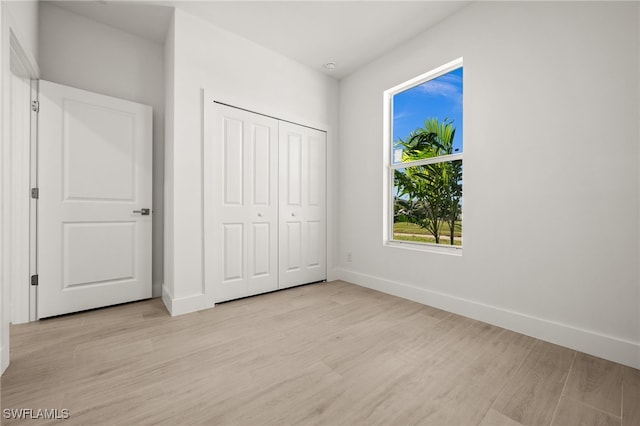 unfurnished bedroom with a closet and light hardwood / wood-style flooring