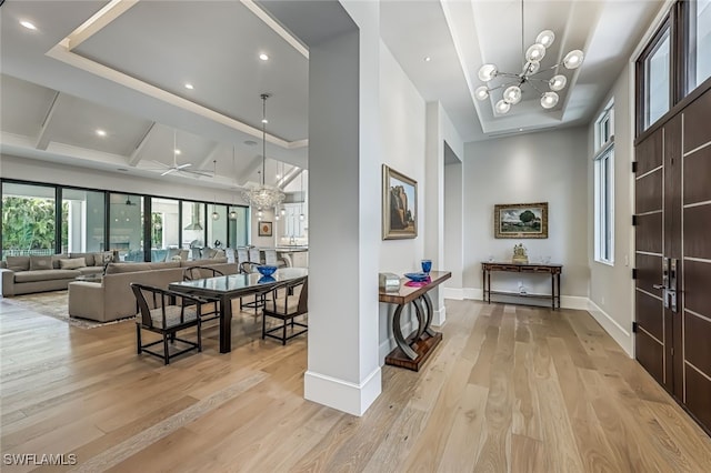 interior space with a chandelier, a high ceiling, and light hardwood / wood-style flooring