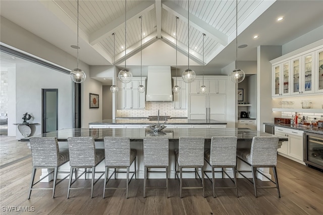 kitchen featuring pendant lighting, light stone counters, and a large island