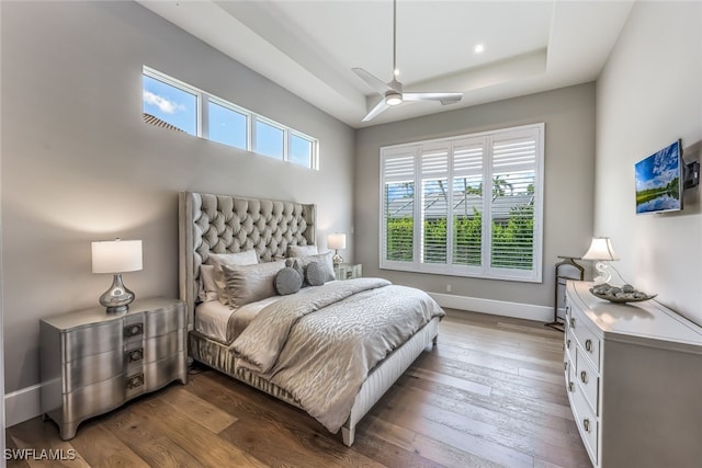 bedroom with wood-type flooring, multiple windows, and ceiling fan