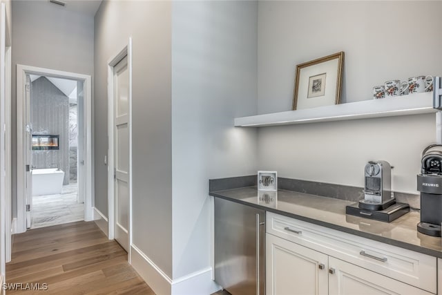 interior space featuring white cabinets, stainless steel fridge, and light hardwood / wood-style floors