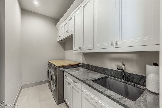 laundry room featuring cabinets, separate washer and dryer, light tile patterned flooring, and sink