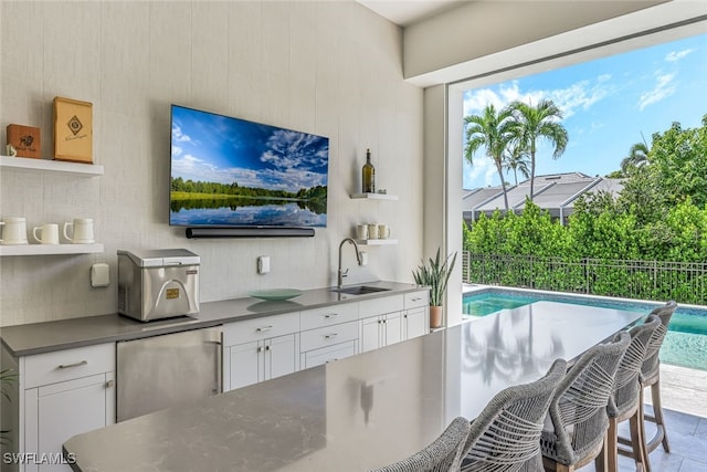 interior space with white cabinets, stainless steel fridge, a healthy amount of sunlight, and sink