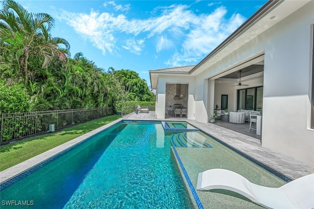 view of swimming pool with ceiling fan and a patio area