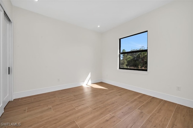 spare room with light wood-style flooring and baseboards